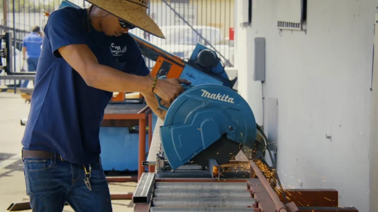 C&R Metals worker cutting steel with saw