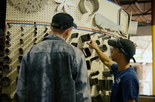 C&R Metals worker assisting client at parts wall